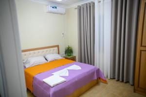 a bedroom with a bed with towels on it at Vila BENE in Pogradec