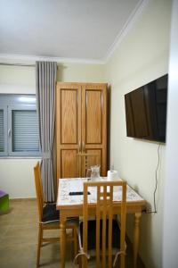 a dining room with a table and chairs and a television at Vila BENE in Pogradec
