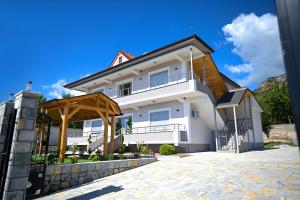 a large white house with a roof at Vila BENE in Pogradec
