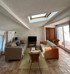 ein Wohnzimmer mit zwei Sofas und einem Fernseher in der Unterkunft Leucate in Leucate
