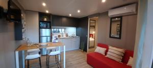 a small kitchen with a table and a red couch at Campeggio Internazionale Frassanito in Otranto