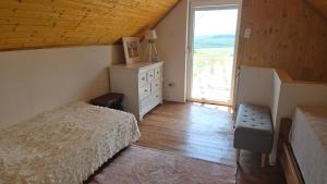 a bedroom with a bed and a dresser and a window at Zinnia Vendégház in Nagyrada
