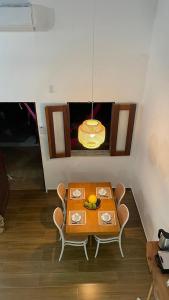 a dining room with a table with chairs and a light at Chalé Brisa do Rio in Paulino Neves +5 photos