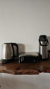 a coffee maker and a toaster on a wooden table at Chalé Brisa do Rio in Paulino Neves
