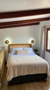 a bedroom with a large bed with a striped comforter at Chalé Brisa do Rio in Paulino Neves