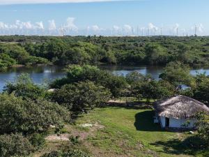 a small hut on a field next to a river at Chalé Brisa do Rio in Paulino Neves