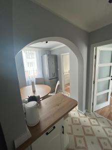 a kitchen with a wooden table and an archway at Pavels Cozy Nook in Smolyan