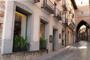 an alley in a city with plants in windows at Hotel Reina Cristina in Teruel