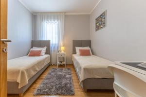 two beds in a small room with a window at Villa Antonela in Radetići +24 photos