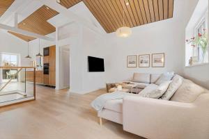 a living room with a white couch and a tv at 8569-Grenaa-Kystvej-3-b in Grenå Strand