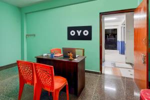 an office with two chairs and a desk with a sign on the wall at Hotel O White Inn in Chennai