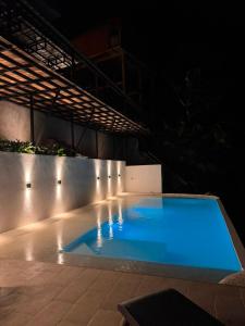 a large blue swimming pool at night with lights at Montes De Beraka in Minca