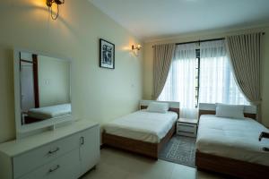 a bedroom with two beds and a large mirror at Bella Vista Villas Ltd in Mbarara