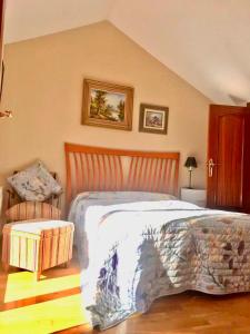 a bedroom with a large bed and a chair at Casa de Aurora in Rubí
