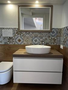 a bathroom with a sink and a toilet and a mirror at Cuore Selargius in Selargius +10 photos