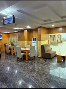 a dining room with tables and chairs and a couch at Goldstep hotel Okpaka in Warri +25 photos
