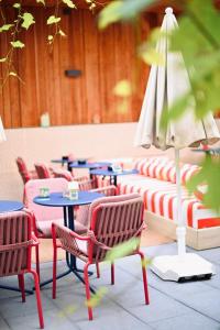 a row of chairs and tables and an umbrella at ClapClap Hôtel Strasbourg in Strasbourg +41 photos
