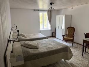 a bedroom with two beds and a desk and a chair at Le Moulin au Fil de l'Eau - 5 moulin Busselin 52250 ORCEVAUX in Verseilles-le-Bas