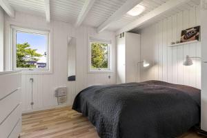 a bedroom with a bed and two windows at C11596-Hemmet-Vester-Faelled-51 in Hemmet