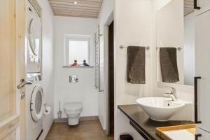 a white bathroom with a sink and a toilet at 8571-Grenaa-Kaprifolievej-20 in Grenå Strand +17 photos