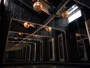 a room with a mirror and lights on the wall at Caporizon - La Damoiselle in Chancelade