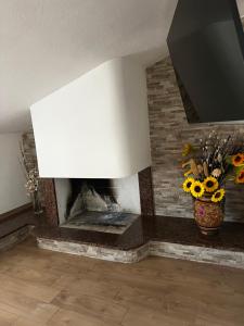 a living room with a stone fireplace with a tv at Cuore Selargius in Selargius