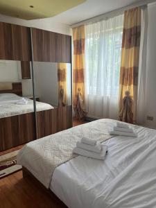 a bedroom with two beds with towels on top of it at Casa Primaverii in Râşnov