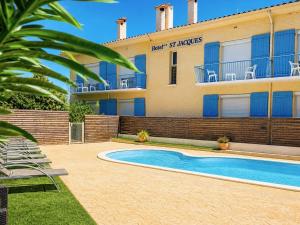 a hotel with a swimming pool in front of a building at Hôtel Saint Jacques in Sorède