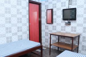 a room with a red door and a table and a tv at SIU Elite INN in Chennai +22 photos