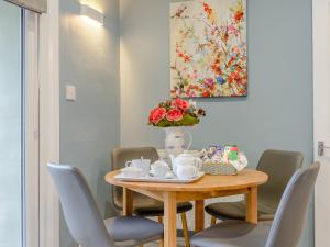 a dining room table with chairs and a vase with flowers at High Haven in Amble
