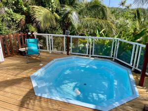 a blue pool on a deck with a chair at Kaz Robinson Cabane Perchee Vue Mer Vivez l aventure Robinson avec le confort d une vue imprenable sur les Caraibes in Terre-de-Bas +13 photos