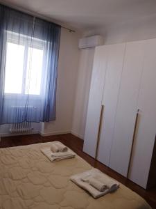 a room with a bed and a window and towels at Beautiful Home Mxp in Gallarate
