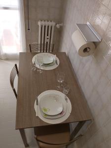 a table with two plates and wine glasses on it at Beautiful Home Mxp in Gallarate +20 photos
