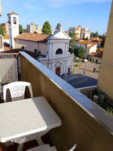 a white table and chair on a balcony with a building at Beautiful Home Mxp in Gallarate