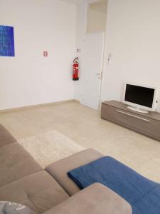 a living room with a couch and a tv at Beautiful Home Mxp in Gallarate