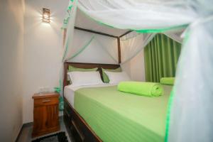 a bedroom with a green bed with a canopy at Rainforest Hide View in Deniyaya +59 photos