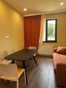 a living room with a table and a couch at "Mtis broli 77"-Mzetamze-Borjomi in Mzet'amze