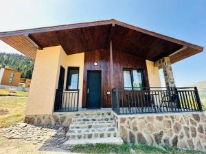 a small house with a balcony and a blue door at "Mtis broli 77"-Mzetamze-Borjomi in Mzet'amze
