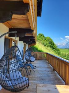 a porch with two chairs and a swing at Chalet Moralee mit Whirlpool in Kitzbühel by ONE VILLAS in Kitzbühel +36 photos