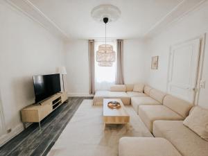 a living room with a couch and a tv at Champagne getaway, spacious house in Épernay