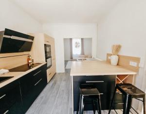 a kitchen with a counter and two stools at Champagne getaway, spacious house in Épernay
