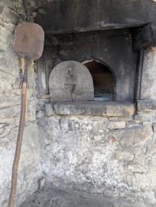 a stone oven with a spatula in it at All About You Montefiore in Casola in Lunigiana