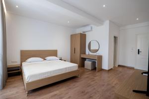 a bedroom with a large bed and a mirror at Vila 2M in Sarandë +56 photos