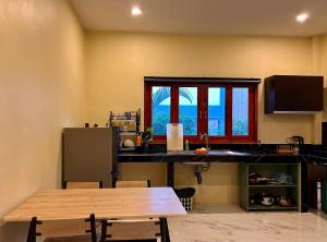 a kitchen with a counter and a table and a window at Spacious 2BR Mint house in Ban Nok +3 photos