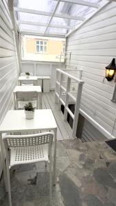 a patio with two tables and benches and a greenhouse at ONS 2026 Economic Central accommodation in Stavanger