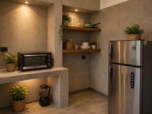 a kitchen with a stainless steel refrigerator and a microwave at Ceylon Stays Hiriketiya in Nilwella