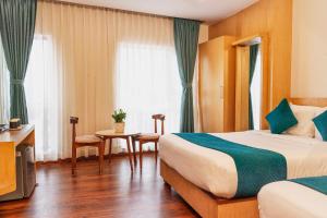 a hotel room with a bed and a table at Marlo Hotels in Kathmandu