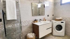 a bathroom with a washing machine and a sink at CASA NICOLAS 158 by SalentoAffitti in Neviano +9 photos