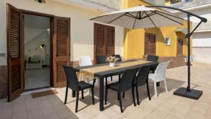 a table and chairs with an umbrella on a patio at CASA NICOLAS 158 by SalentoAffitti in Neviano