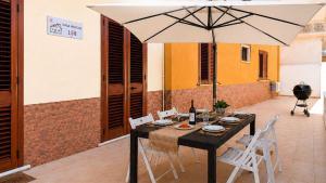 a table with chairs and an umbrella on a patio at CASA NICOLAS 158 by SalentoAffitti in Neviano